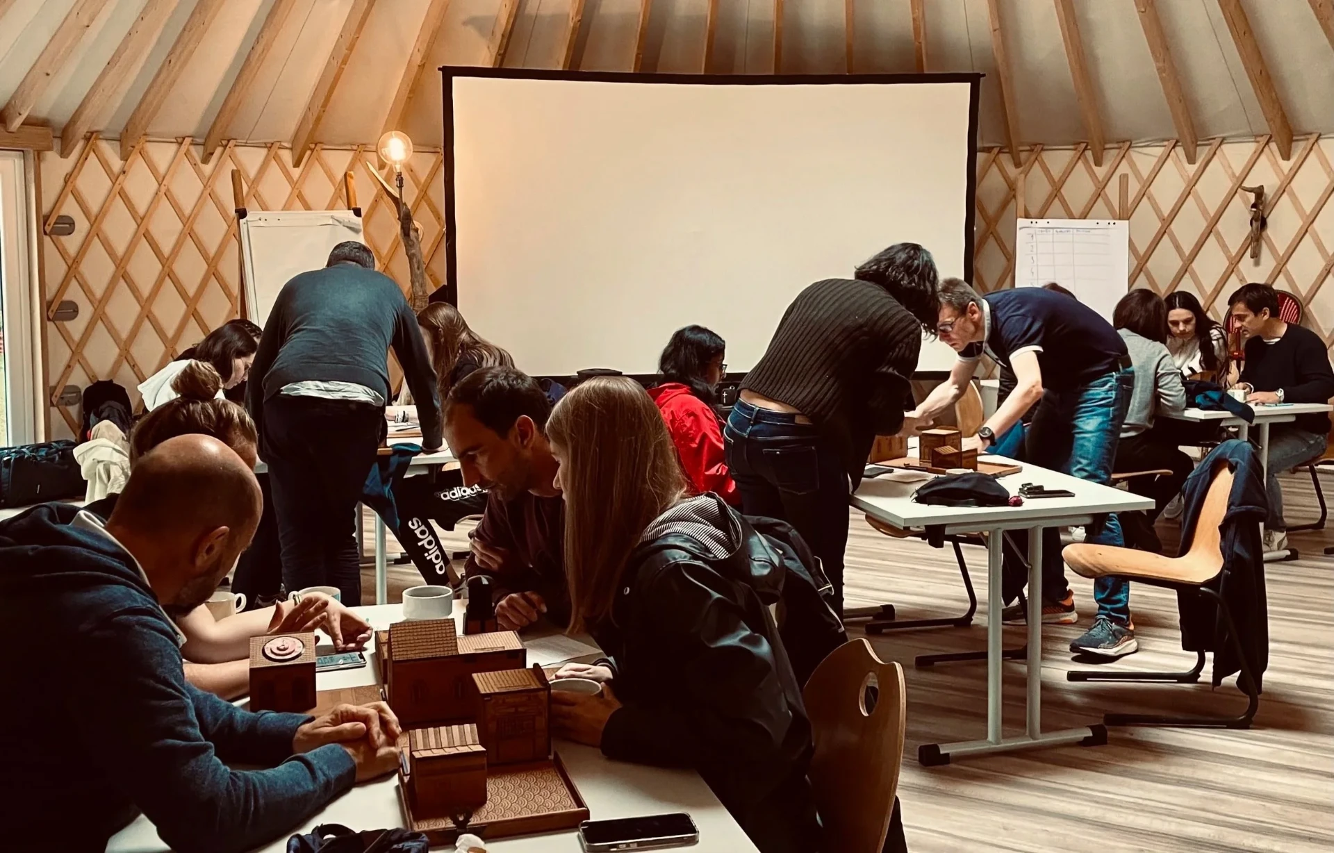 Equipa reunida em espaço acolhedor a colaborar em torno de caixas de puzzle